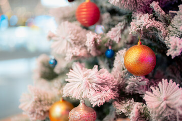 Closeup snowy Christmas tree decoration,red,gold,silver ornament with bokeh background. Perfect holiday sales, winter celebration, festive seasonal promotions, marketing, shopping with copy space