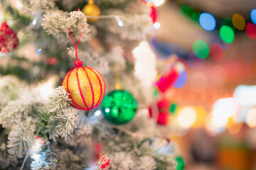 Closeup snowy Christmas tree decoration,red,gold,silver ornament with bokeh background. Perfect holiday sales, winter celebration, festive seasonal promotions, marketing, shopping with copy space