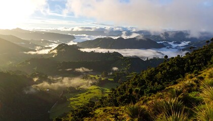A breathtaking landscape photo showing mountain ranges partially obscured by clouds, with patches of sunlight