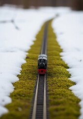 Miniature steam train on a mossy track with snowy landscape detailing