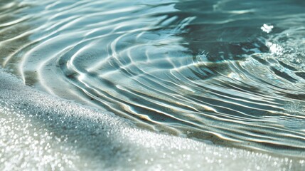 Tranquil water ripples gently caressing sandy beach under warm sunlight, creating a serene and peaceful atmosphere for relaxation and reflection