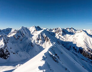 Snow Covered Mountain Peaks Under a Clear Blue Sky