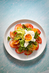 Fresh salad with tomatoes and boiled egg on white plate, diet recipe
