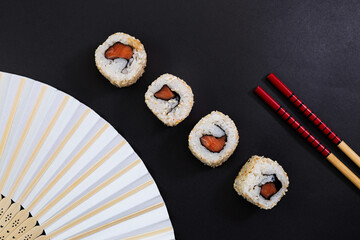 Sushi rolls with salmon on black background