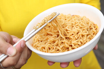 Spicy instant noodles bowl eating and hand