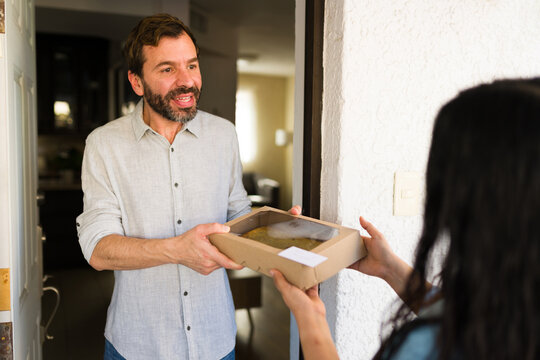 Neighbor cheerfully receiving a box with delicious food from a woman, symbolizing convenient home delivery and online ordering