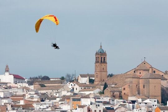 Paramotor flying above antequera cityscape in andalusia