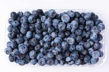 Blueberries in a plastic container isolated on a white background.