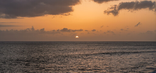 Serene sunset scene, Calm sunset casting golden glow on peaceful maritime horizon