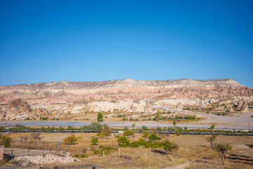 A breathtaking panoramic view of Cappadocia&rsquo;s layered rock formations, showcasing unique geological patterns and soft pastel colors created by centuries of erosion