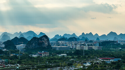Aerial view of urban city buildings and mountain landscape with dramatic sky in Guilin.