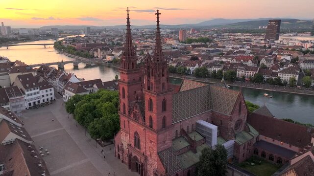Basel City in Switzerland on Summer Morning. Orange Dawn over the Basler Munster, Church Square and Old town, Aerial.