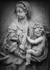 Stone relief of Madonna and Child at Goat Gate Cemetery in Bratislava, photographed in black and white.