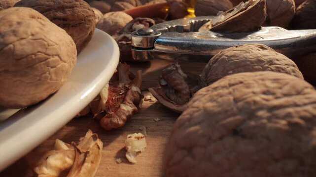 Walnuts with nutcracker on wooden table close up.