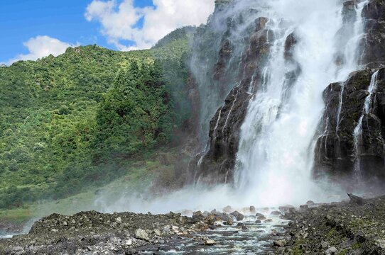 Waterfalls flanked by forested slopes of Himalayas. Tawang District, Arunachal Pradesh, India.