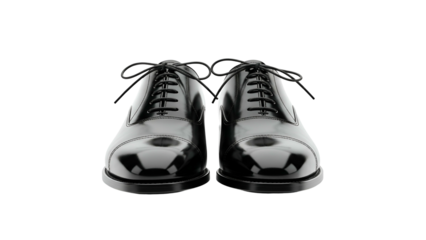 A pair of polished black leather dress shoes against a stark black background