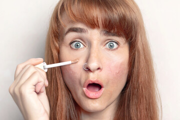 Caucasian woman is surprised that the concealer perfectly covers up dark circles under her eyes and skin imperfections. White background
