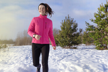 Happy caucasian sports woman runs in the snow in winter. Winter sports, activity close up