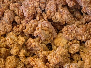 Crispy, golden-brown fried chicken pieces or popcorn chicken, close-up, full-frame texture.