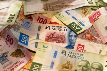 Several Mexican banknotes of various denominations.
