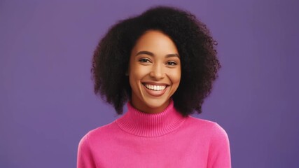 Portrait of a smiling young woman with dark curly hair wearing pink turtleneck sweater on a purple background - Powered by Adobe