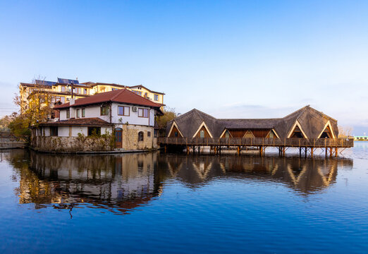 Landscape with a building built on the lake and reflected on the water surface with blue sky