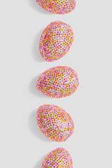 Decorative pink easter eggs in colorful sequins as minimal festive background ol light gray. Pop art still life photo of sparkling rhinestones pink egg, spring easter holiday modern design, copyspace.