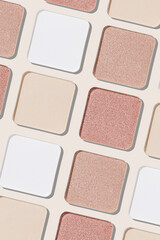 Swatches eyeshadow refills as minimal monochrome pattern. Matte and glitter pans white beige pink shades, detailed texture, sun light, stylish cosmetics background, beauty product, eye makeup
