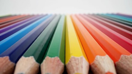 Row of aligned, sharpened colored pencils in vibrant rainbow hues against a white backdrop, focus on foreground pencils - Powered by Adobe