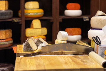 Cheese display with cutting board and cheesewheel in a rustic shop setting for culinary photography
