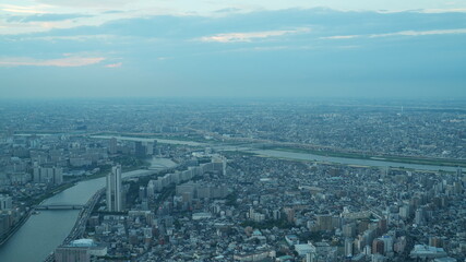 The panoramic city view from the top of the skyscraper building with the sunset sky as background