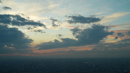 The panoramic city view from the top of the skyscraper building with the sunset sky as background