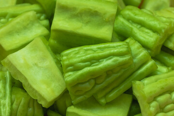 Fresh Chinese bitter melon, sliced and prepared for cooking, showing vibrant green color and texture.