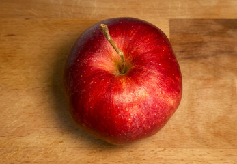 Perfectly Red and Ripe Apple on a Natural Wooden Surface, Shot from Above with Minimalist Styling
