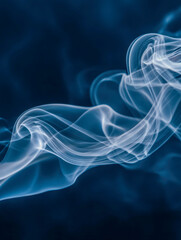 Fototapeta premium Delicate wisps of white smoke swirling gracefully against a deep blue background, creating an ethereal and mesmerizing abstract pattern in motion