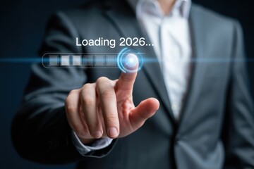 Man in suit touching loading bar with loading 2026 text on a dark blue gradient background