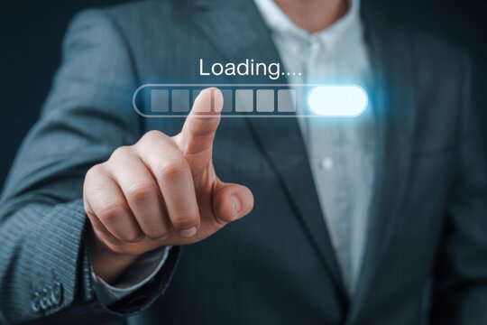 A person in a suit touching a loading bar on a screen with the word loading above the bar shown