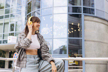 Young woman enjoying music in urban street style