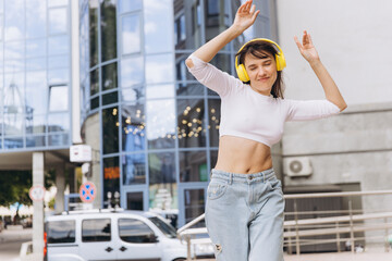 Woman enjoying music dancing in urban street