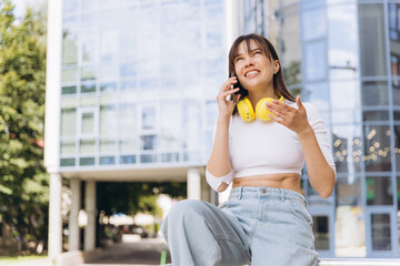 Fototapeta premium Woman talking on phone communicating outdoors in city