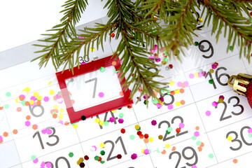 There is a paper calendar on the table with a reminder of the Christmas holiday.