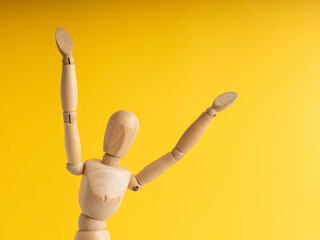 Wooden mannequin with arms raised in celebration pose