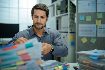 Worried businessman with insomnia working overtime on important documents. Shows depression,...