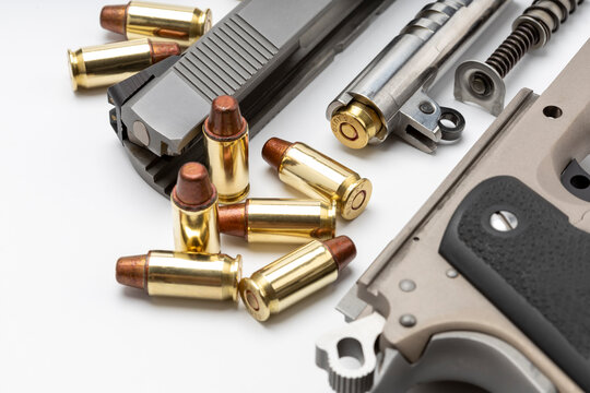 Parts of 1911 gun model and .45 bullets on white background