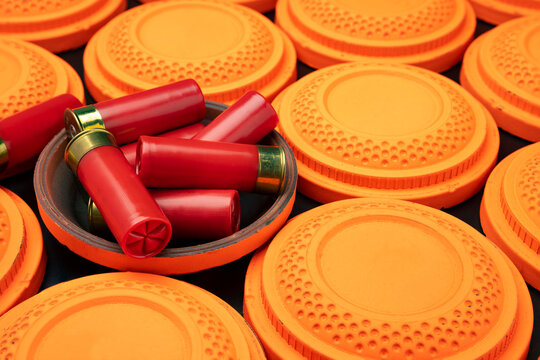 Clay disc flying targets and shotgun bullets on black background ,Clay Pigeon target