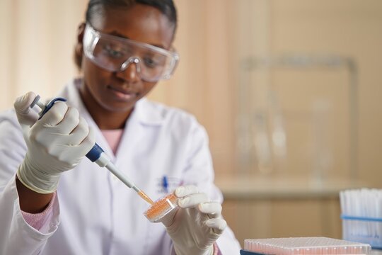 Laboratory technician preparing cell cultures using precise pipetting in a clean lab