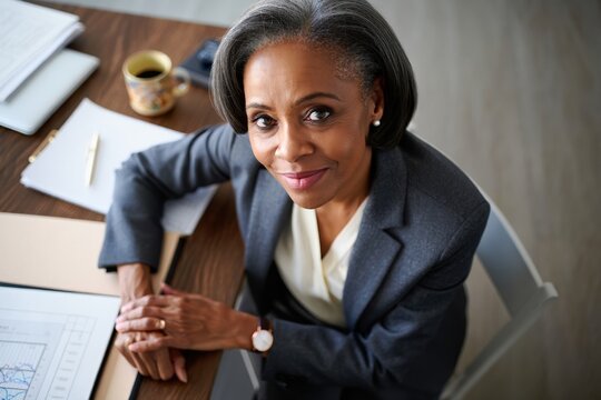 Senior accountant facing front, professional portrait at desk with documents.