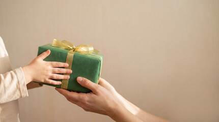 Child Hands Receiving Green Gift Box from Parent Hands