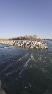Peaceful seaside view with shining stones and distant trees