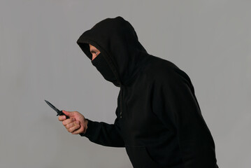 Hombre encapuchado amenazante con una navaja